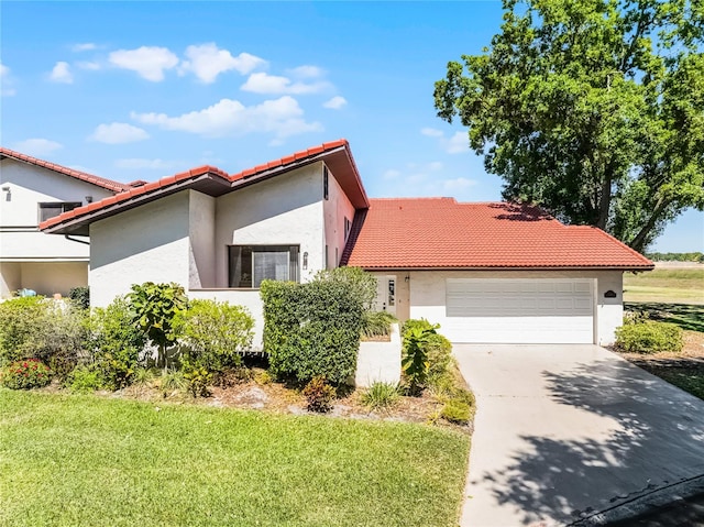 mediterranean / spanish-style house with driveway, stucco siding, an attached garage, and a tiled roof