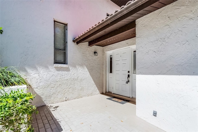 entrance to property featuring stucco siding