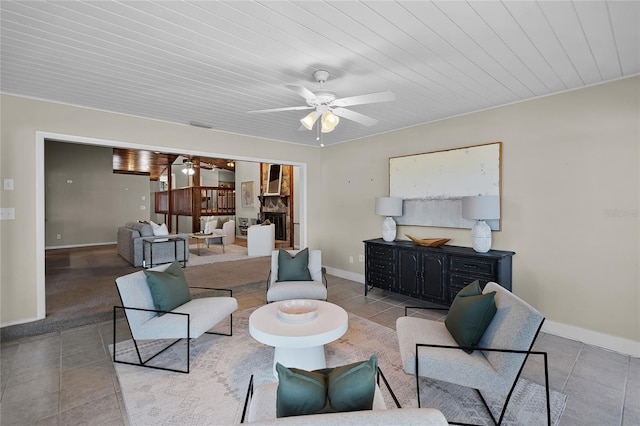tiled living area with baseboards and ceiling fan