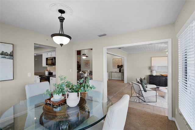 dining space with light tile patterned floors, light carpet, baseboards, and visible vents