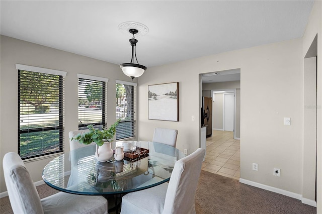 carpeted dining room featuring tile patterned flooring and baseboards