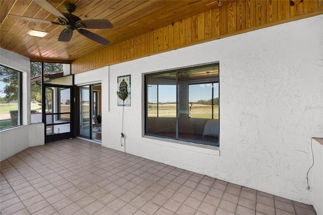 unfurnished sunroom featuring a ceiling fan and a healthy amount of sunlight