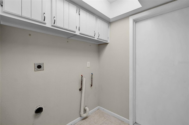washroom with light tile patterned flooring, electric dryer hookup, cabinet space, and baseboards