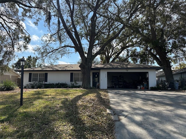 ranch-style home with an attached garage, driveway, a front lawn, and stucco siding