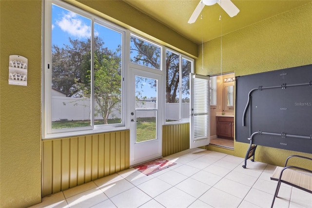 unfurnished sunroom featuring a wealth of natural light and ceiling fan