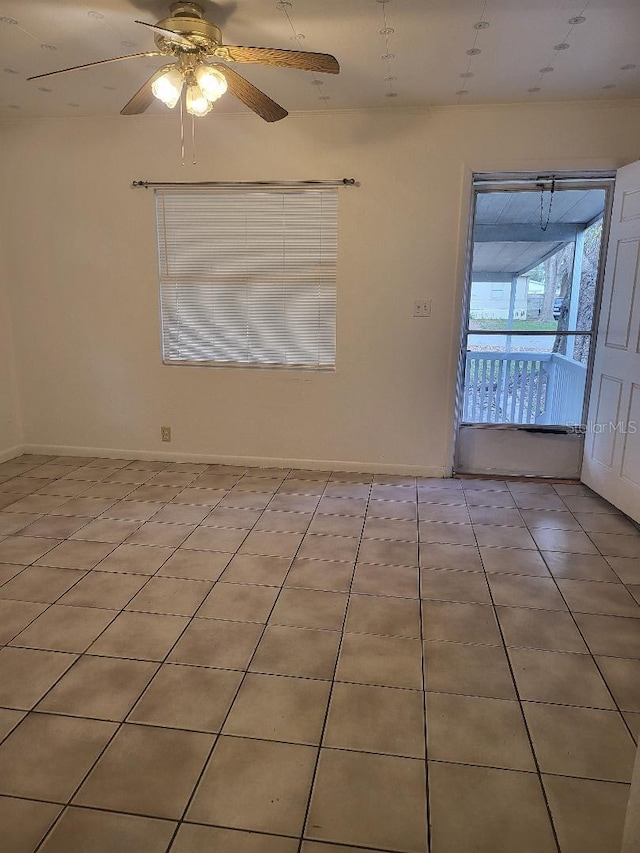 tiled empty room featuring ceiling fan