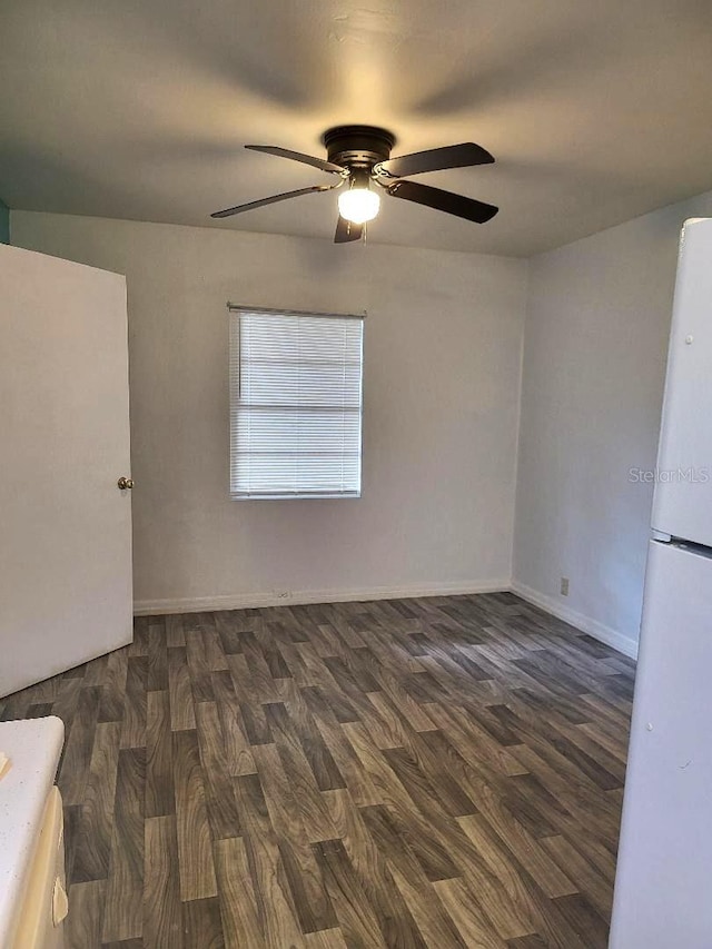 spare room with dark hardwood / wood-style flooring and ceiling fan