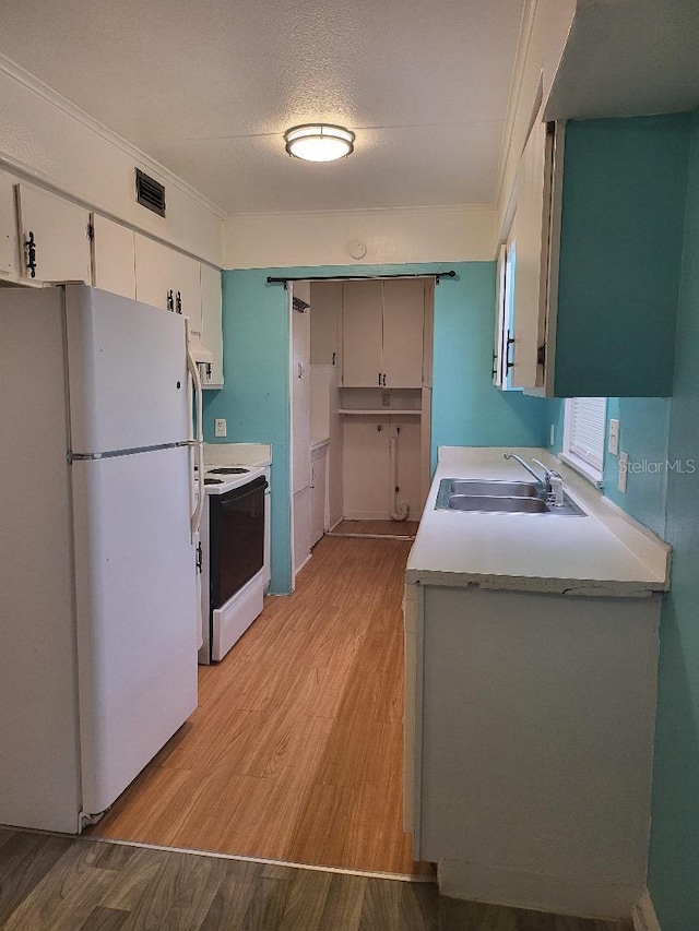 kitchen with range with electric cooktop, white cabinetry, sink, white fridge, and light wood-type flooring