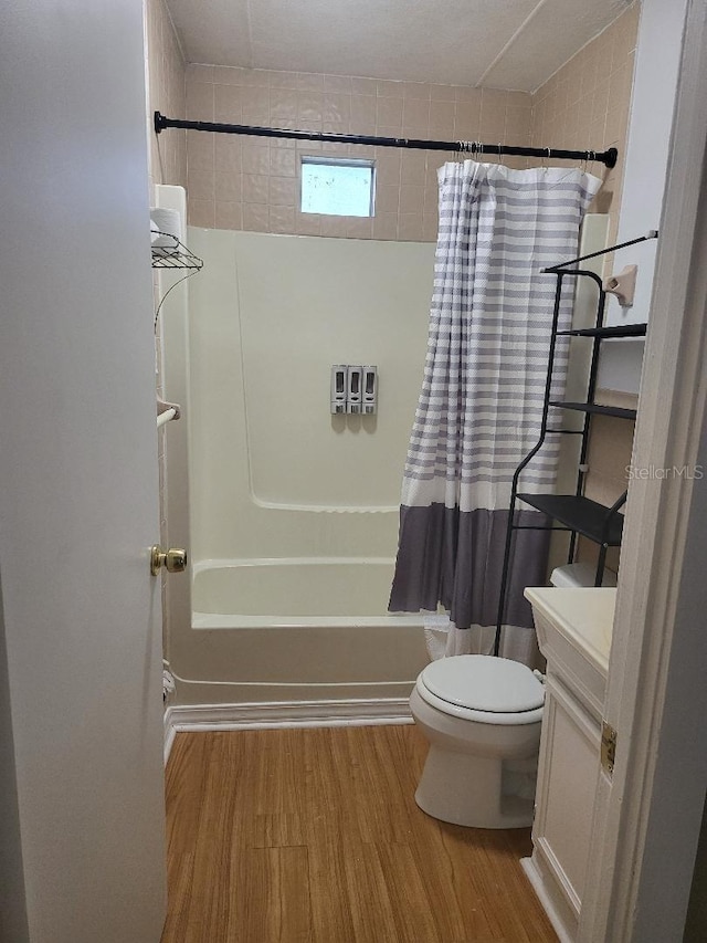 full bathroom with vanity, hardwood / wood-style floors, shower / tub combo, and toilet