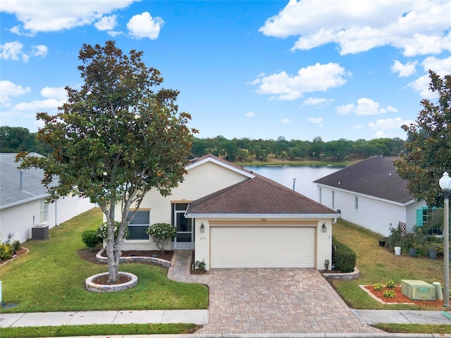 ranch-style house with a garage, a water view, central AC unit, and a front yard