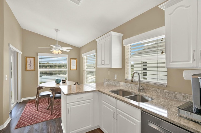 kitchen featuring lofted ceiling, stainless steel dishwasher, sink, white cabinetry, and kitchen peninsula