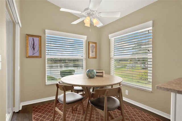 dining room featuring a healthy amount of sunlight, dark wood-type flooring, and ceiling fan