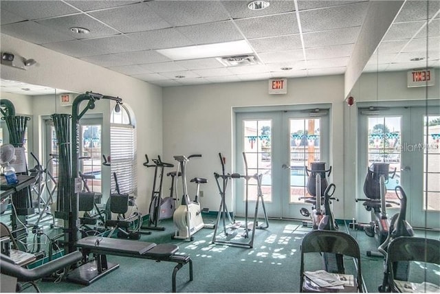 gym with a drop ceiling, carpet floors, and french doors