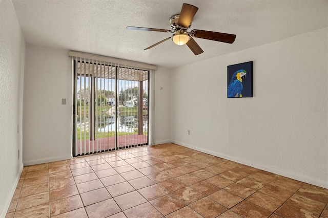 tiled spare room featuring ceiling fan, a textured ceiling, and a water view