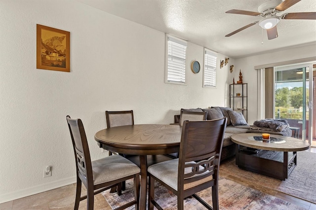 dining space with ceiling fan and a textured ceiling