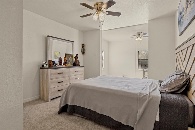 carpeted bedroom with ceiling fan and a textured ceiling