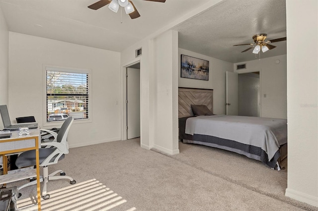 bedroom featuring light carpet, a textured ceiling, and ceiling fan