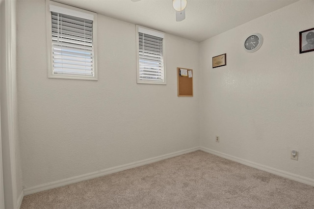 carpeted spare room featuring ceiling fan