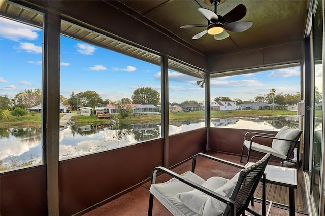 sunroom / solarium with a water view and ceiling fan