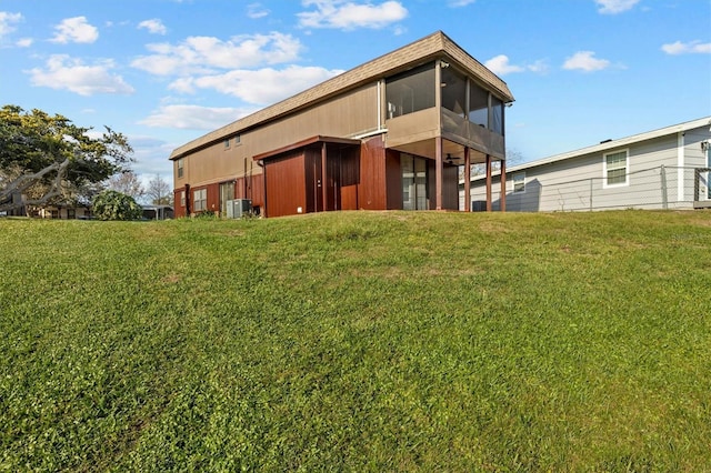 back of property featuring a sunroom, a yard, and cooling unit