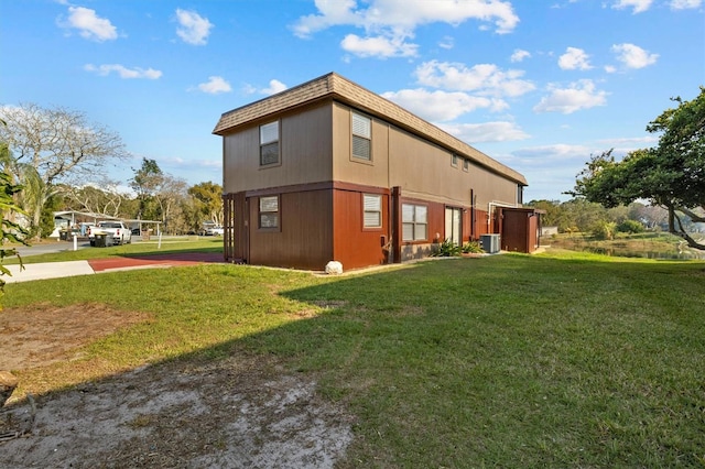 view of side of property featuring cooling unit and a lawn