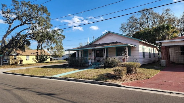 view of front of property featuring covered porch and a front lawn