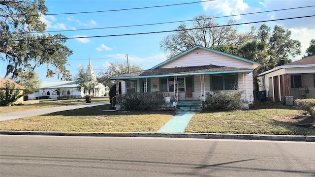 bungalow-style house with a front yard and covered porch