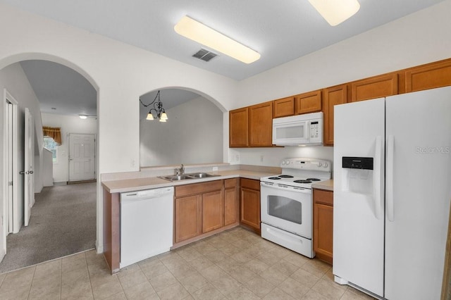 kitchen featuring sink, an inviting chandelier, decorative light fixtures, light carpet, and white appliances