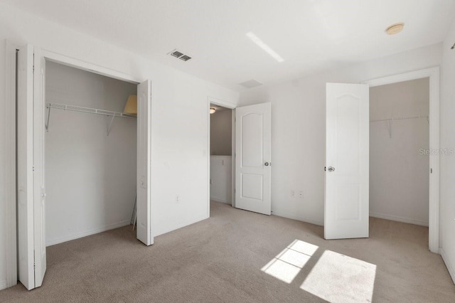 unfurnished bedroom with light colored carpet and a closet