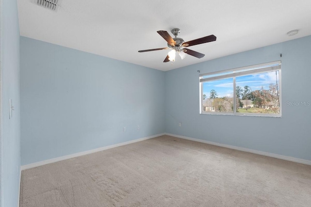 empty room with ceiling fan and light carpet