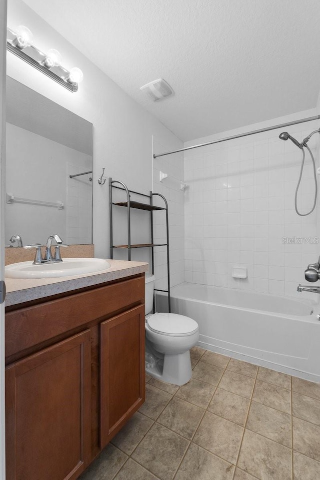 full bathroom featuring tile patterned floors, toilet, a textured ceiling, vanity, and tiled shower / bath combo