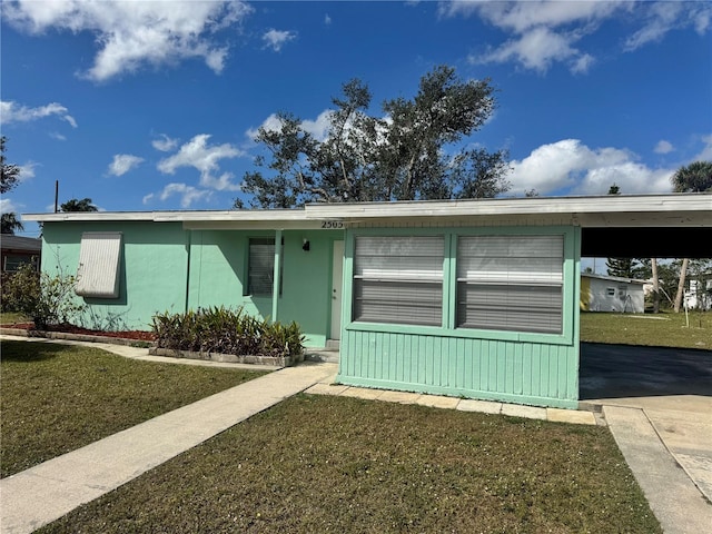 single story home featuring a carport and a front yard