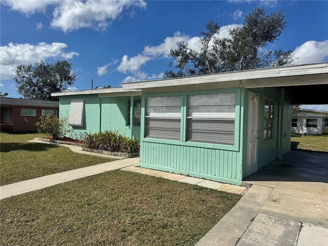 view of side of home with a yard and a carport