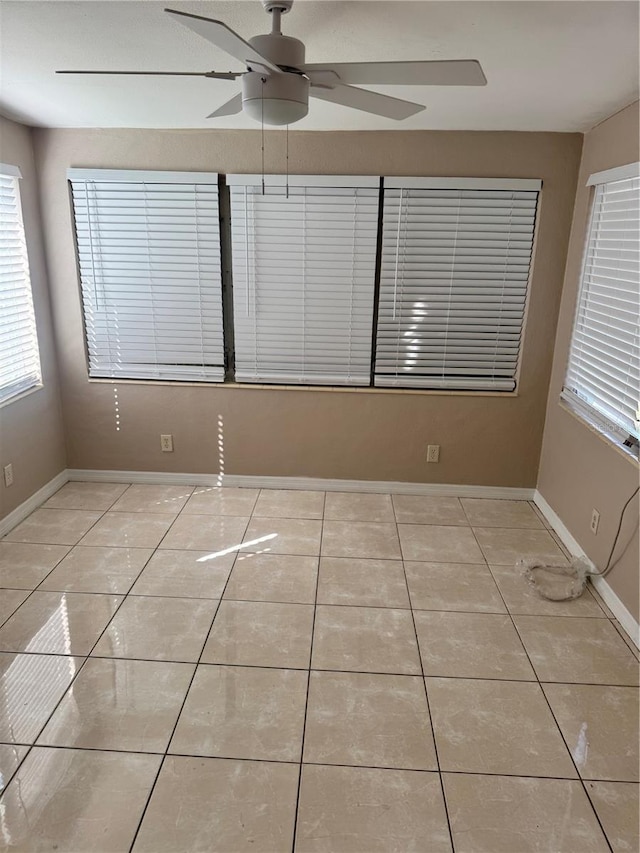 tiled empty room featuring ceiling fan