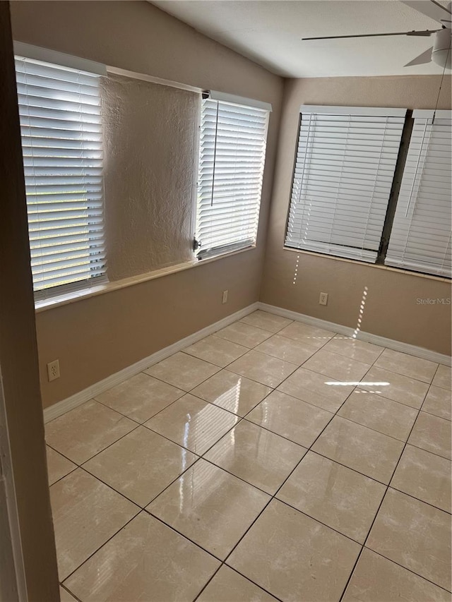 empty room with light tile patterned flooring and ceiling fan