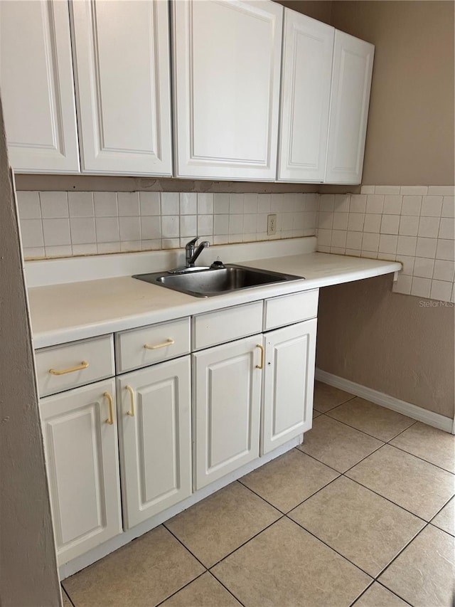 kitchen featuring white cabinetry, sink, and light tile patterned flooring