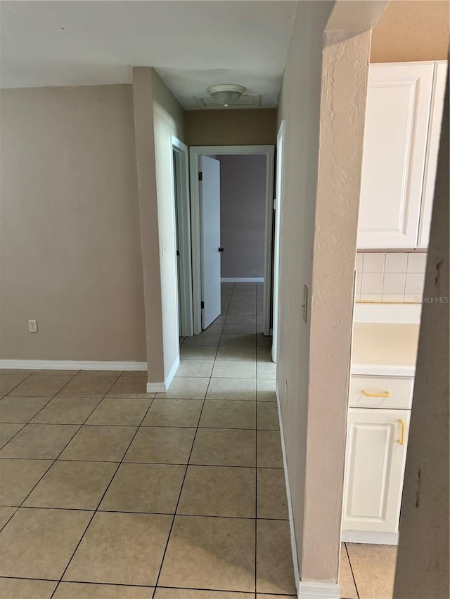 hall with tile patterned floors