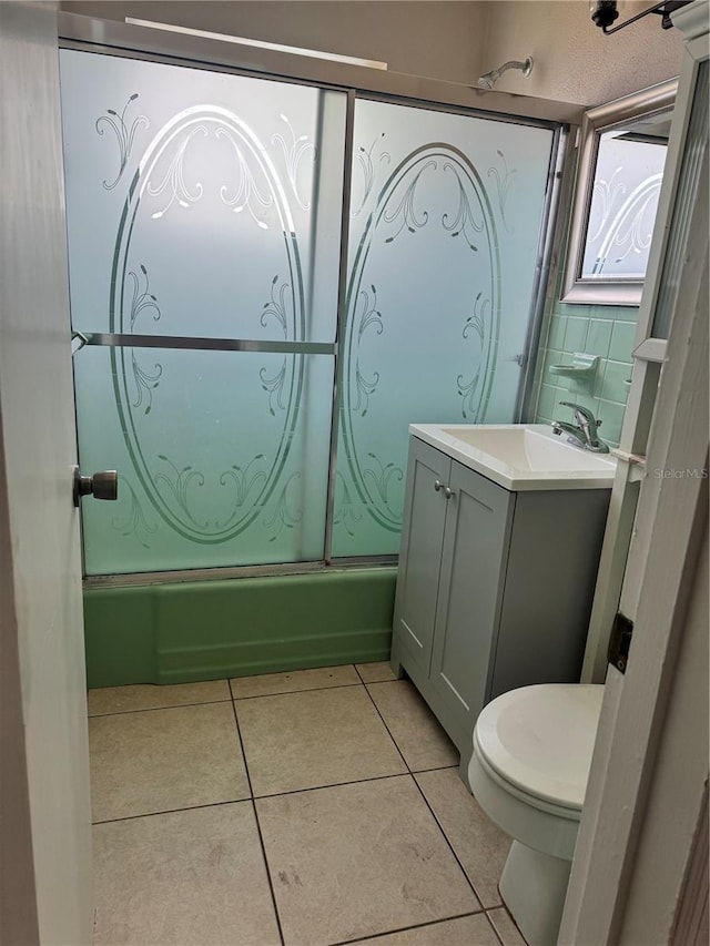 full bathroom featuring vanity, tile patterned floors, toilet, and combined bath / shower with glass door