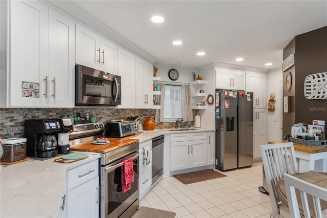 kitchen with white cabinetry, appliances with stainless steel finishes, sink, and decorative backsplash