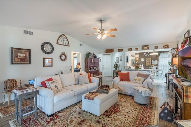 living room with vaulted ceiling, ceiling fan, and wood-type flooring