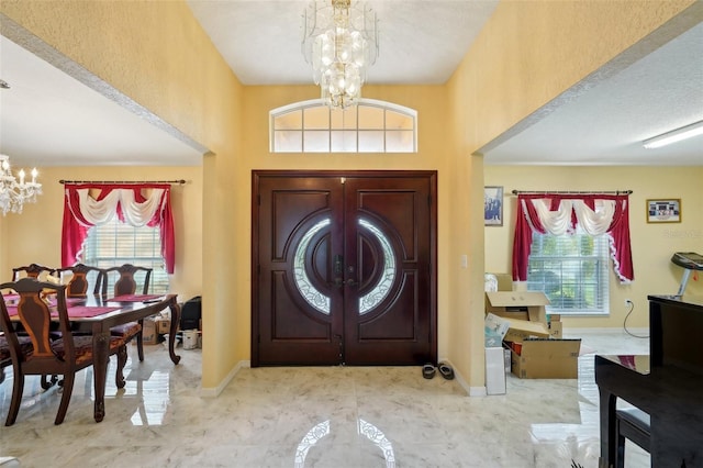 foyer entrance featuring a chandelier and a wealth of natural light