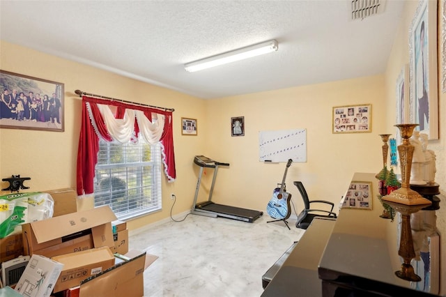 workout room featuring a textured ceiling