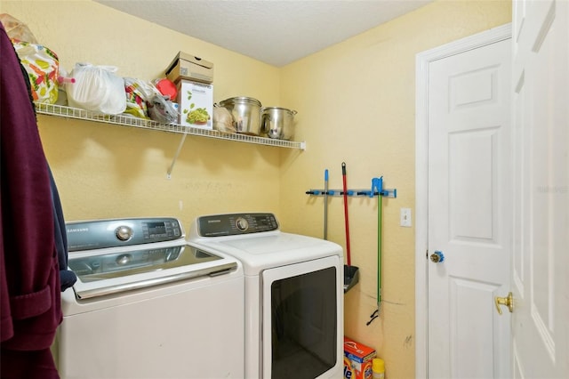 clothes washing area featuring independent washer and dryer and a textured ceiling