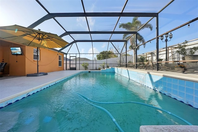 view of pool with a patio area and glass enclosure