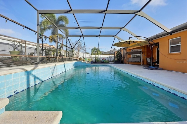 view of swimming pool featuring a patio and a lanai