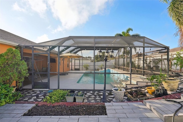 view of pool with glass enclosure and a patio area