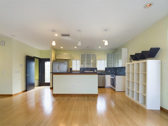 1793 N Fort Harrison Ave, Clearwater, FL 33755 - kitchen featuring hanging light fixtures, appliances with stainless steel finishes, white cabinets, and light hardwood / wood-style flooring