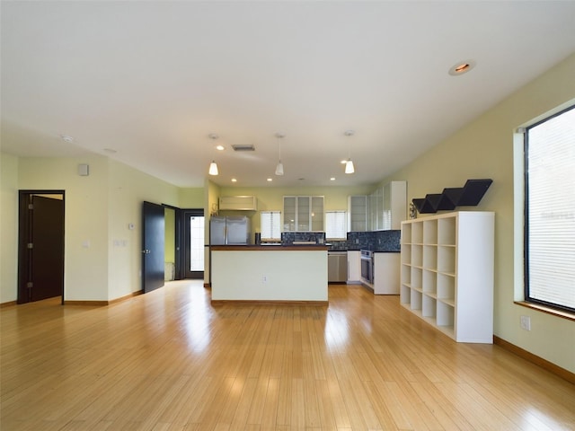 1793 N Fort Harrison Ave, Clearwater, FL 33755 - kitchen with white cabinetry, appliances with stainless steel finishes, hanging light fixtures, and light wood-type flooring