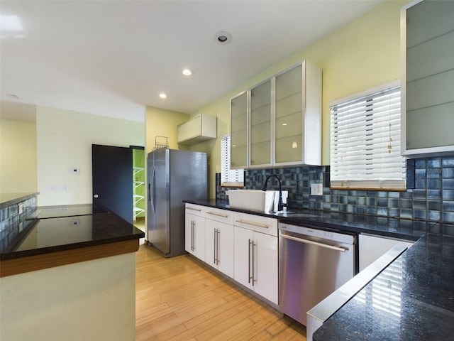 1793 N Fort Harrison Ave, Clearwater, FL 33755 - kitchen with sink, light hardwood / wood-style flooring, stainless steel appliances, white cabinets, and decorative backsplash