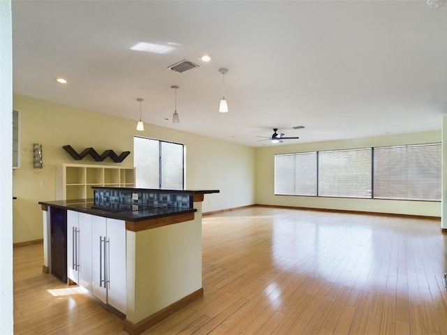 1793 N Fort Harrison Ave, Clearwater, FL 33755 - kitchen featuring white cabinetry, a kitchen island, pendant lighting, ceiling fan, and light hardwood / wood-style floors